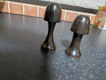Two wooden mushroom-shaped objects on a kitchen counter.