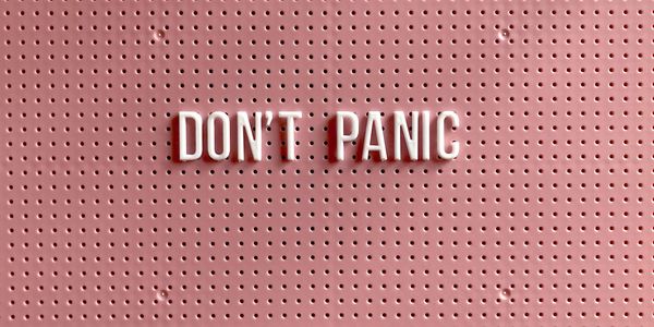 Image of white letters spelling out Don't Panic against a pink background