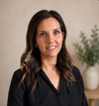 Smiling woman with wavy brown hair in a black top.