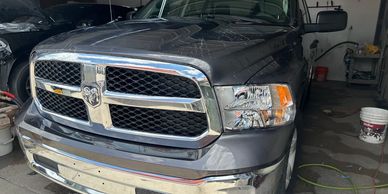 Front view of a gray Dodge Ram truck parked indoors.