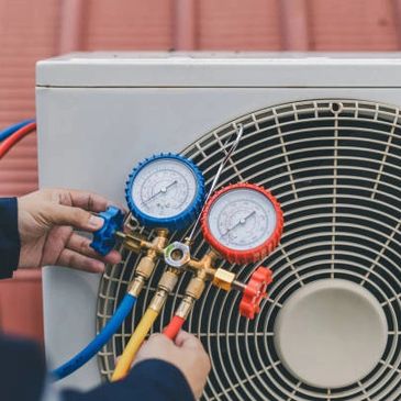Technician adjusting HVAC gauges on an outdoor air conditioning unit.