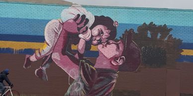 Mural of a man lifting a child.
