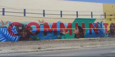 Colorful mural with the word COMMUNITY featuring diverse faces.