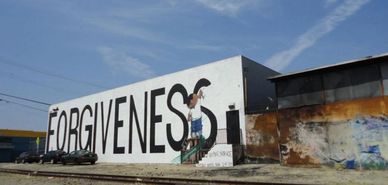 Mural with the word 'FORGIVENESS' painted on a building.