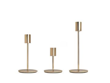 Three gold candle holders of varying heights.