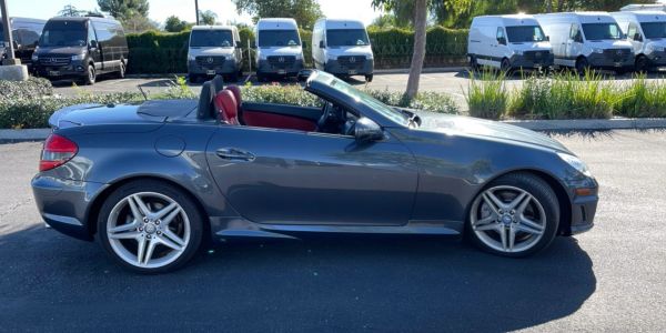 Gray convertible sports car with red interior parked outside.