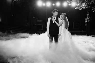 Couple sharing a dance surrounded by fog and lights.