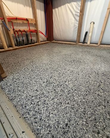 Decorative flake epoxy flooring with a gray and black finish installed by Royal Grand Rubber Solutio