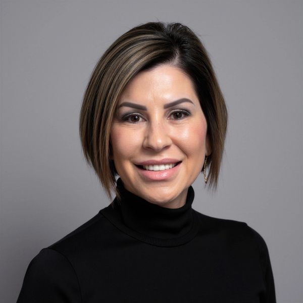 Smiling woman with short hair and black turtleneck.