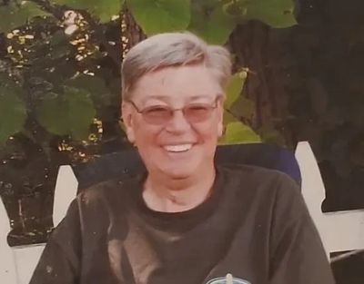 Smiling person wearing glasses outdoors.