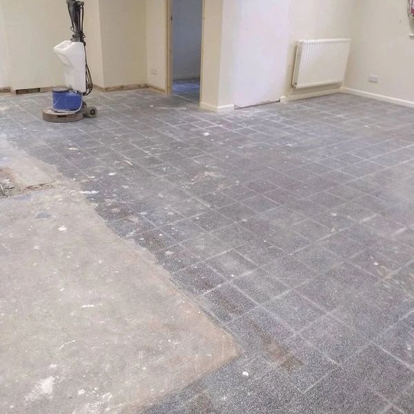 Room with partially stripped floor and polishing machine.