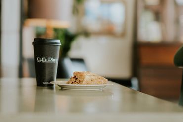 Coffee cup and pastry on a table in a cozy café.