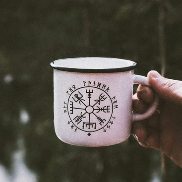 A person holding a ceramic coffee cup on the display
