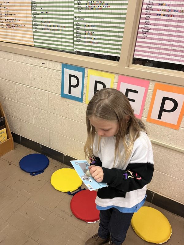 child using a scratch-off reading reward card