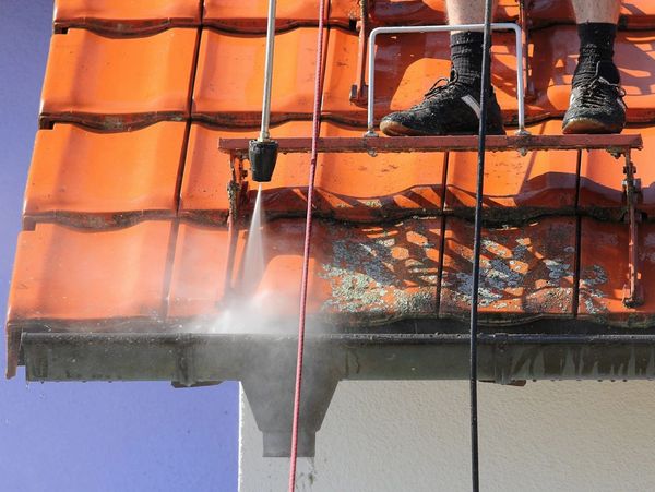 Pressure washing a roof.
