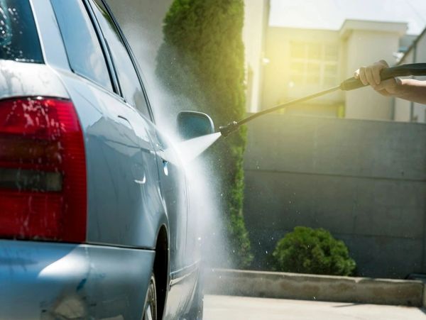 Pressure washing a car.