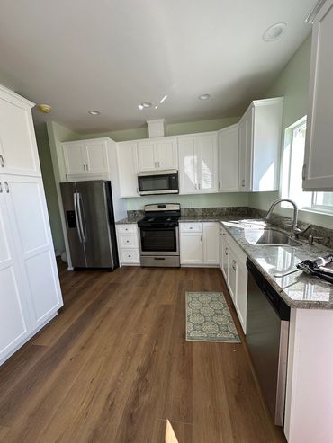 Finished kitchen in Imperial beach ADU with custom cabinets and flooring wit stainless appliances