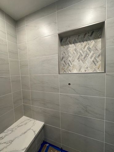 Custom shower niche and bench with quartz tops installed LZ Construction