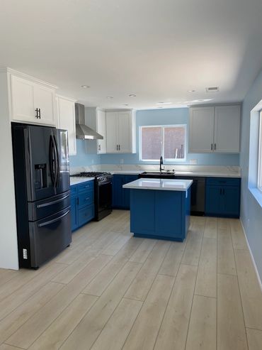 Finished kitchen with blue base cabinets and white upper cabinets