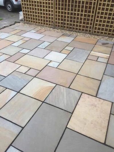 A patio with multi-sized rectangular stone tiles in neutral colors.