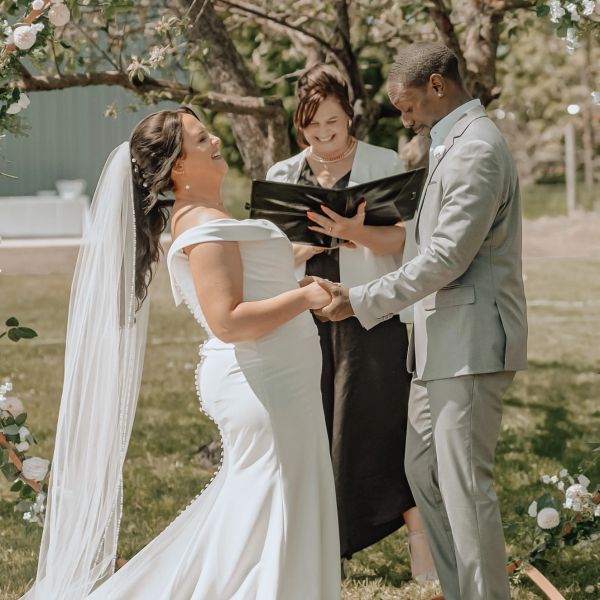Couple laughing during outdoor wedding ceremony.