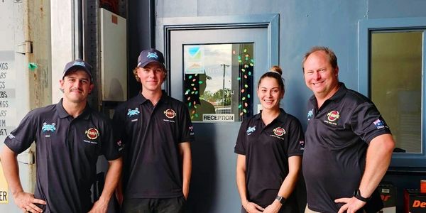 Hales Mechanical team standing together in front of the workshop reception.
