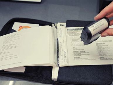 Mechanic stamping a vehicle logbook during scheduled logbook servicing.