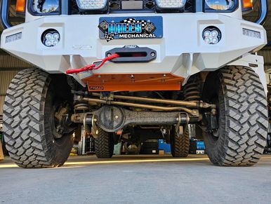 Front view of lifted 4WD showing suspension, recovery gear and off-road upgrades.