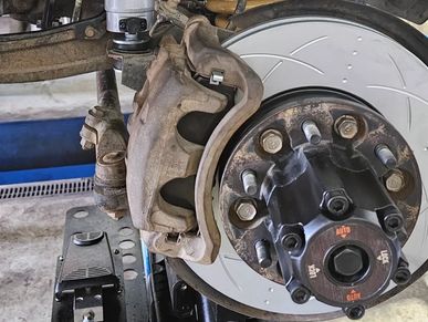 Brake rotor and caliper assembly being serviced on a vehicle