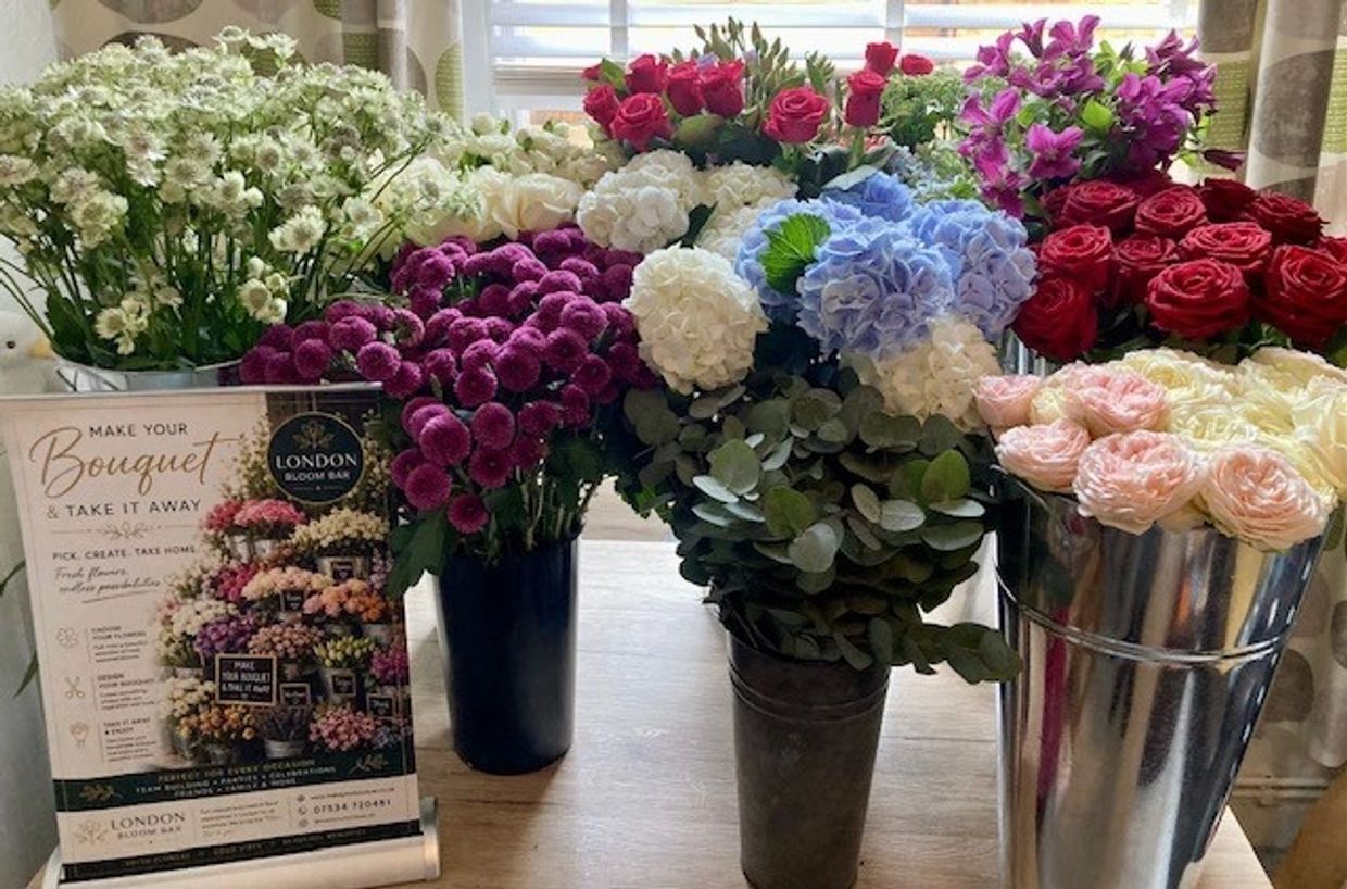Colorful flower bouquets in various vases on a table.