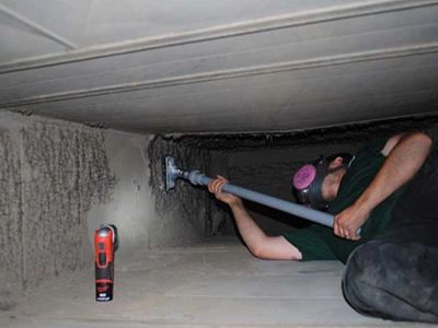 Man in an air duct cleaning