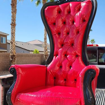 Black frame crocodile red throne positioned in a truck bed for transport or outdoor event setup shot.
