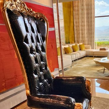 Black gator-skin throne with gold frame placed in upscale Las Vegas suite for luxury photo or VIP guest setting.