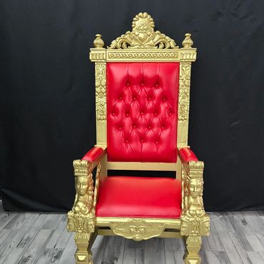 Gold and red tufted square throne with sculpted frame set against black backdrop for rental photo display.
