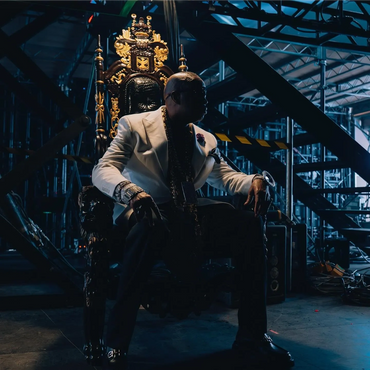 White and gold throne staged on dark set with floating crowns for dramatic brand or performance backdrop.