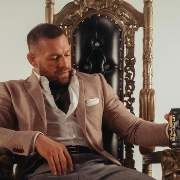 Conor McGregor seated on gold and black lion throne promoting Bucked Up in a luxury product shoot setup.