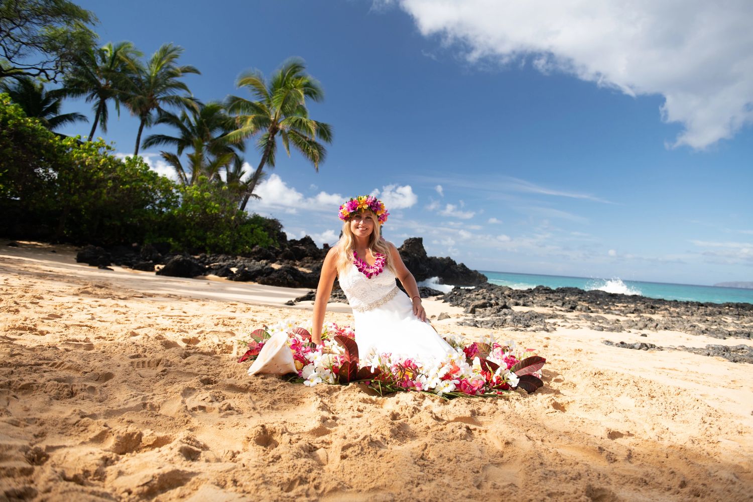 Maui Bride sitting at the beach in flower circle wearing flower haku