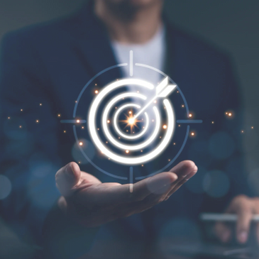 Businessman holding a glowing target with an arrow hitting the center.