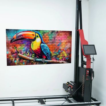 Vibrant toucan mural on a white wall beside a digital printing machine.