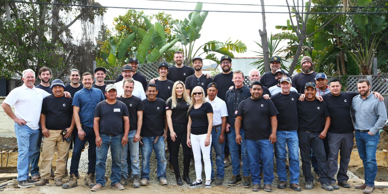Large group of construction workers posing together outdoors.
