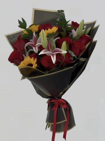 Elegant bouquet with red roses, lilies, and sunflowers wrapped in black paper.
