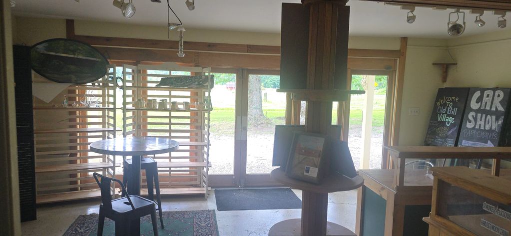 Interior view of a cozy room with rustic furniture and large glass doors.
