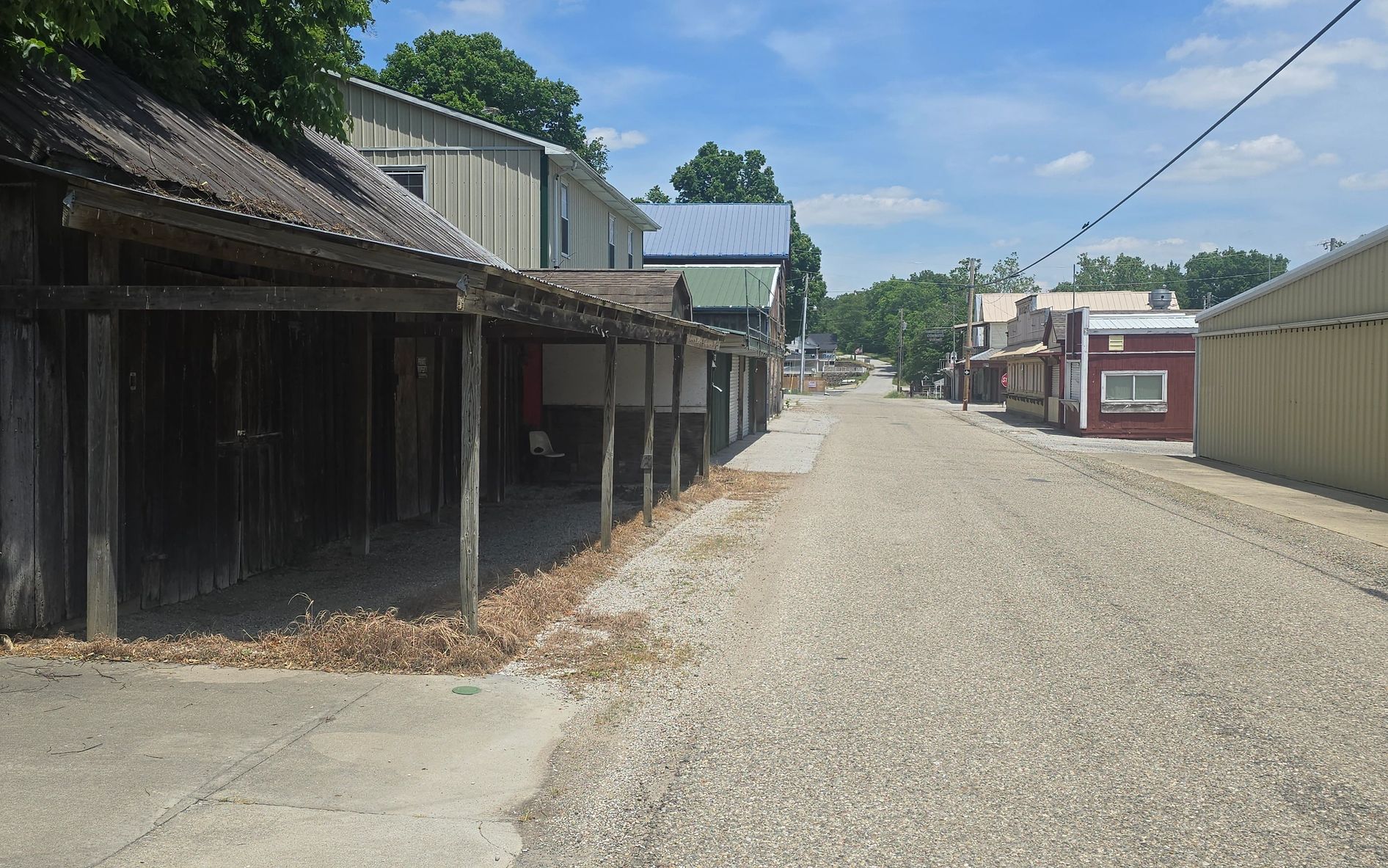 A quiet small-town street with old buildings and clear blue skies.