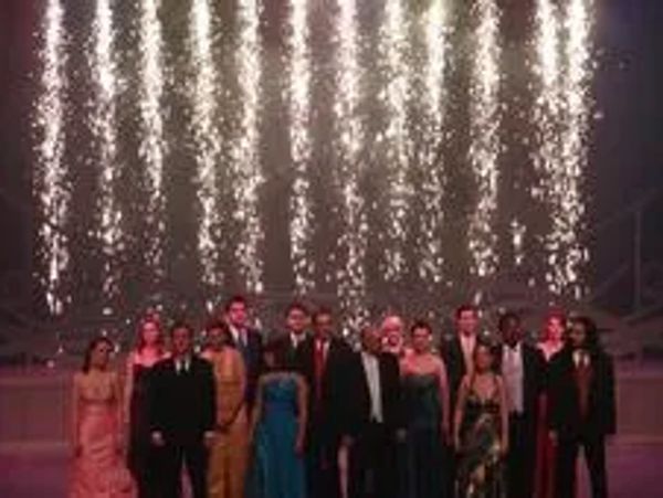 Formal group standing beneath a cascade of sparks.
