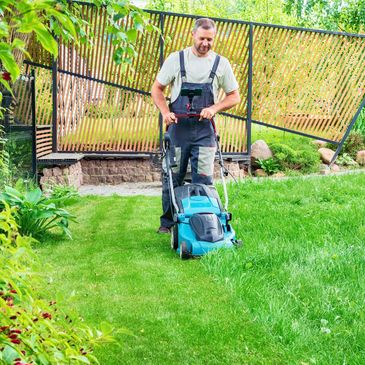 Man mowing a green lawn.