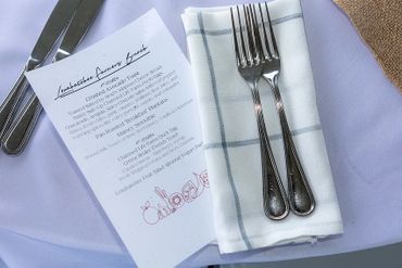 A brunch menu with cutlery and napkin on a table.