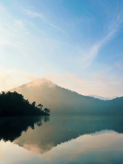 Mountain reflected in calm lake at sunrise.