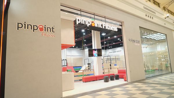 Modern fitness center with a bright, open entrance and bold signage.