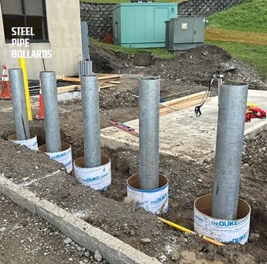 Steel pipe bollards installed in ground.