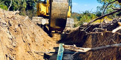 Excavator bucket trenching for underground utility service